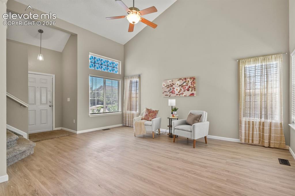 Image 8 of 46: Vaulted ceilings enhance this living area featuring wood-finish flooring