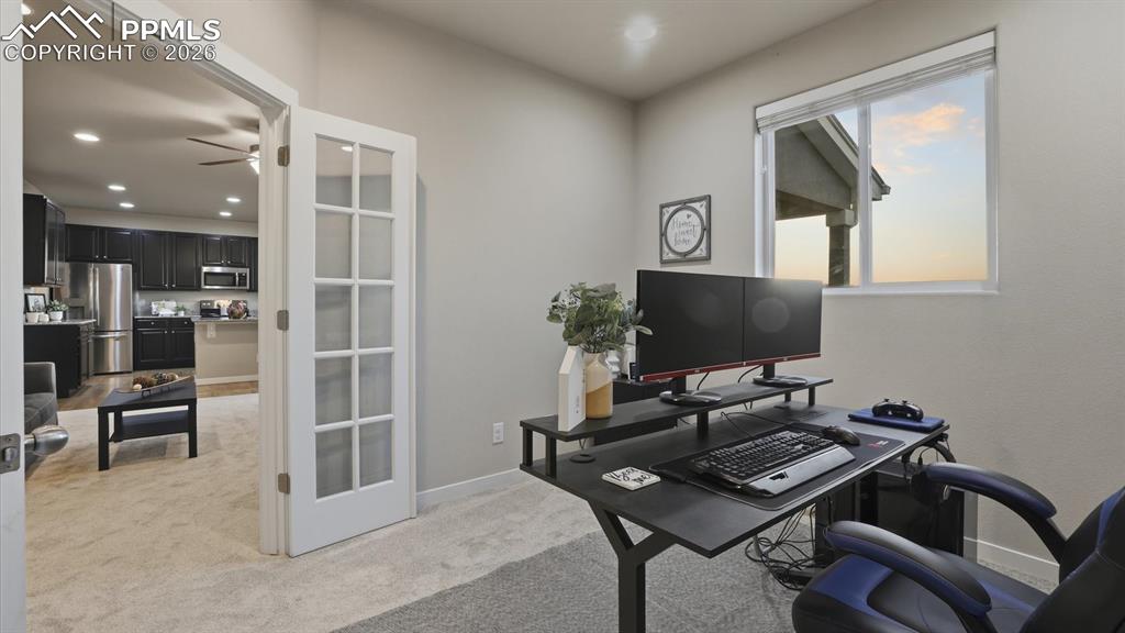 Image 11 of 50: View of stairs to the upper level, French doors into the home office, and L
