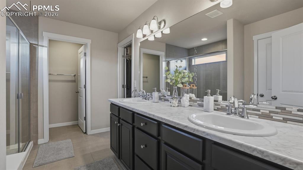 Image 25 of 50: The upper level Primary Bedroom is a private retreat with neutral carpet, a