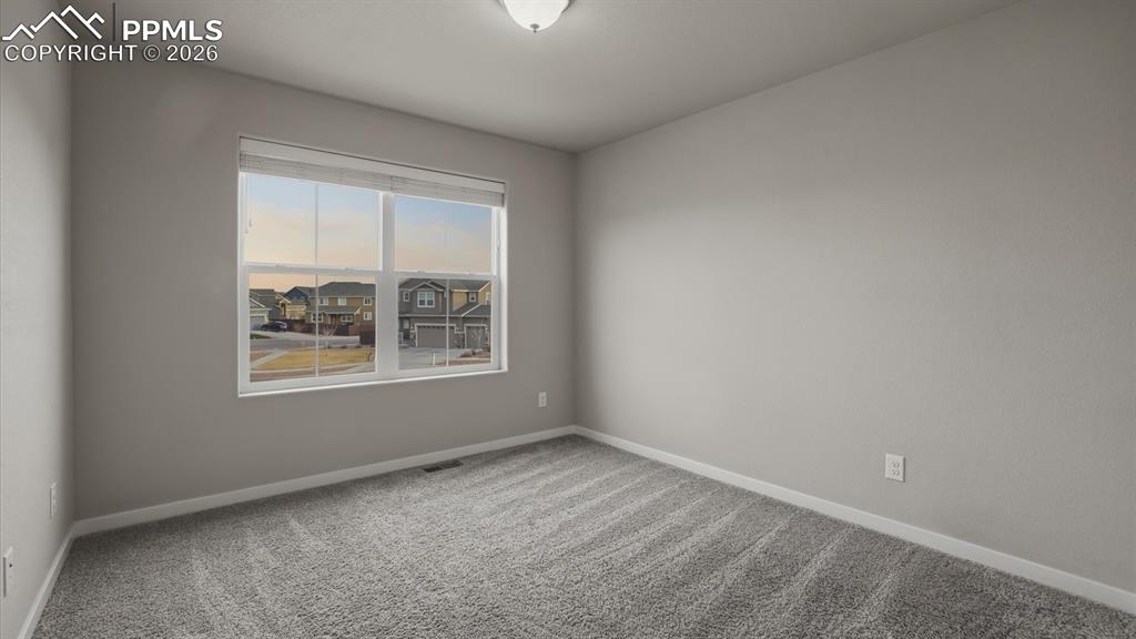 Image 32 of 50: Upper Level Bedroom #2 with neutral carpet.