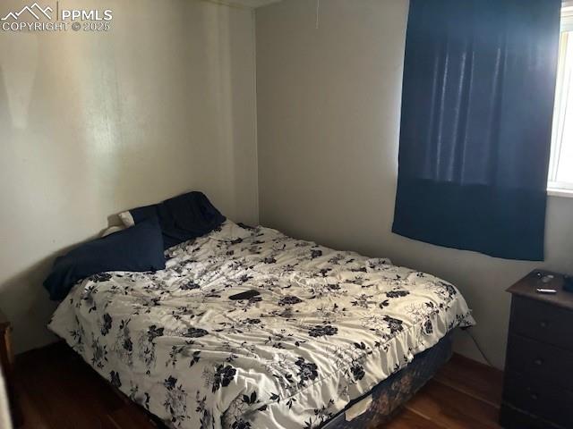 Image 6 of 12: Bedroom with dark wood-type flooring