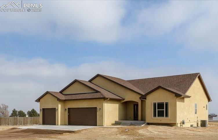 Caption: Single story home with a garage, cooling unit, fence, and stucco siding