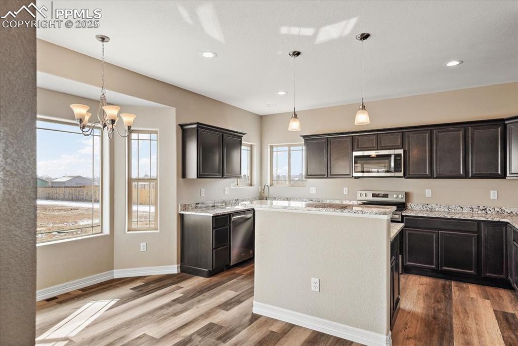 Image 14 of 45: Kitchen with appliances with stainless steel finishes, a center island, han