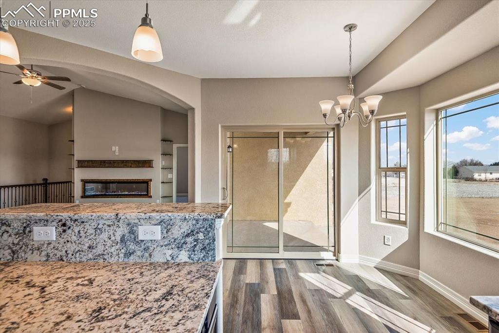 Image 17 of 45: Unfurnished dining area featuring dark wood-style floors, ceiling fan with