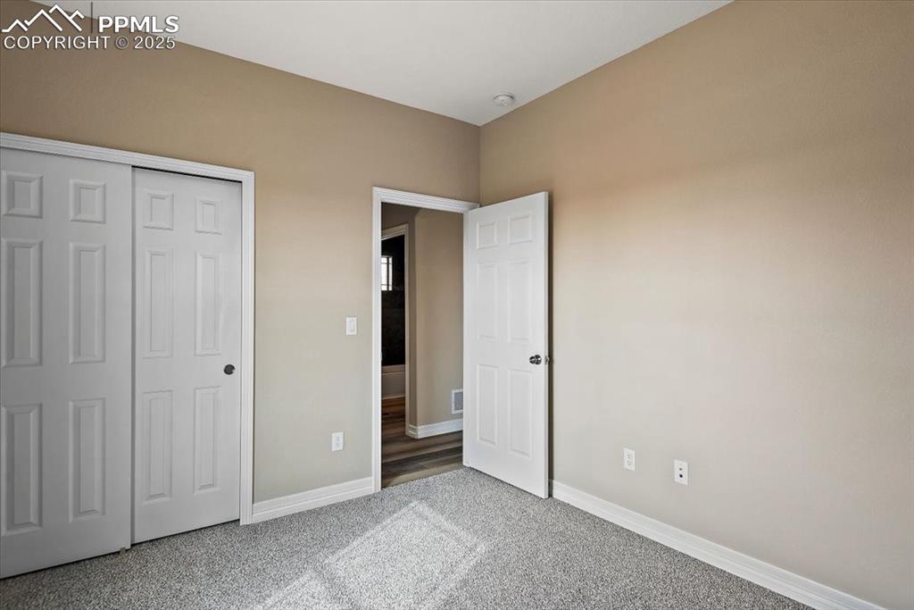 Image 20 of 45: Unfurnished bedroom featuring carpet, baseboards, and a closet