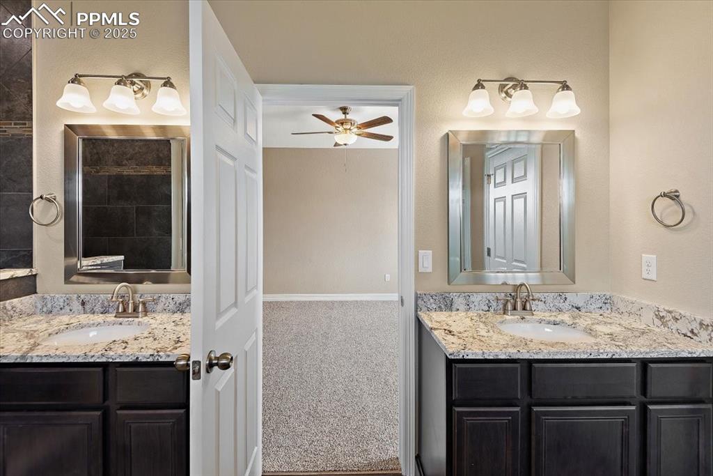 Image 32 of 45: Full bath with ceiling fan, two vanities, and a sink