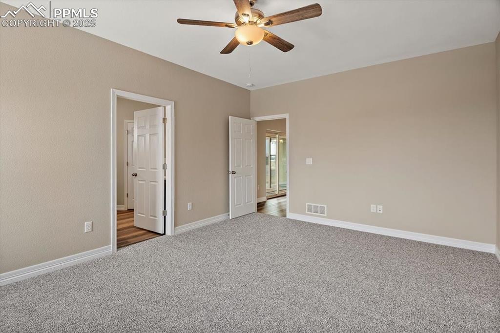 Image 34 of 45: Unfurnished bedroom with carpet, visible vents, ceiling fan, and baseboards