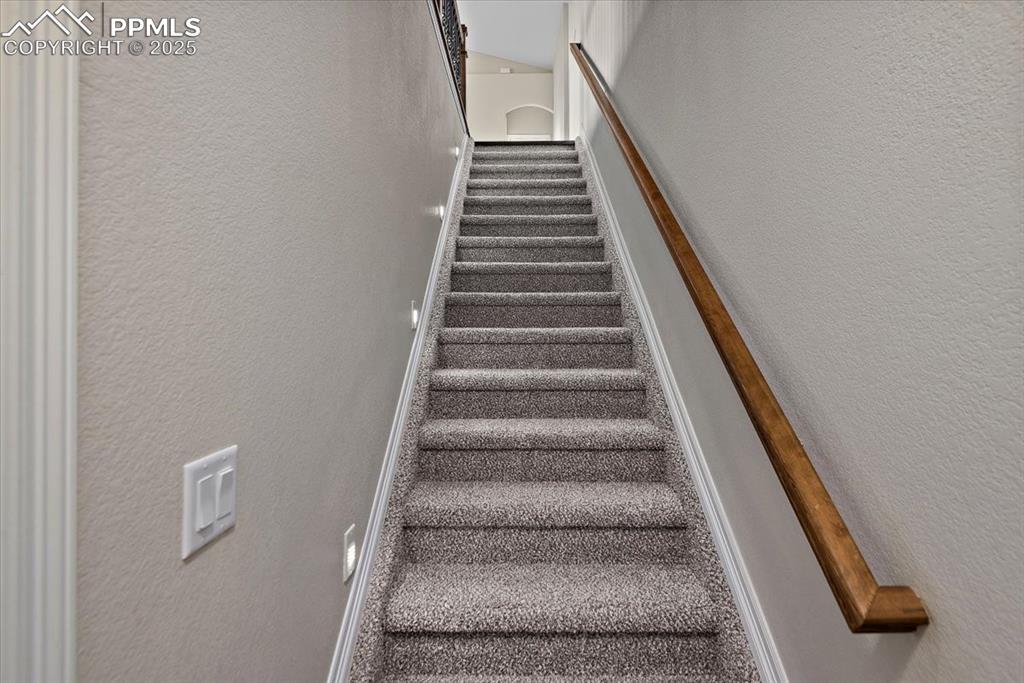 Image 35 of 45: Stairway with a textured wall and baseboards