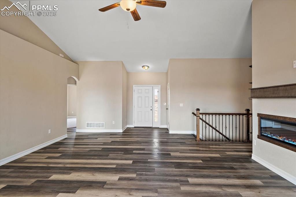 Image 4 of 45: Foyer featuring baseboards, visible vents, arched walkways, and dark wood-t