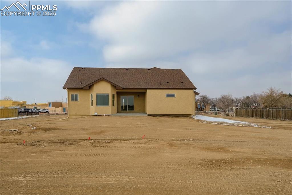 Image 41 of 45: Back of property with fence and stucco siding