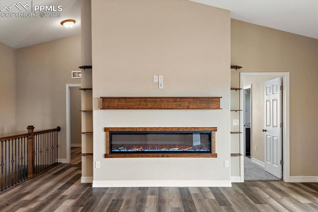 Image 5 of 45: Details featuring a glass covered fireplace, visible vents, baseboards, and