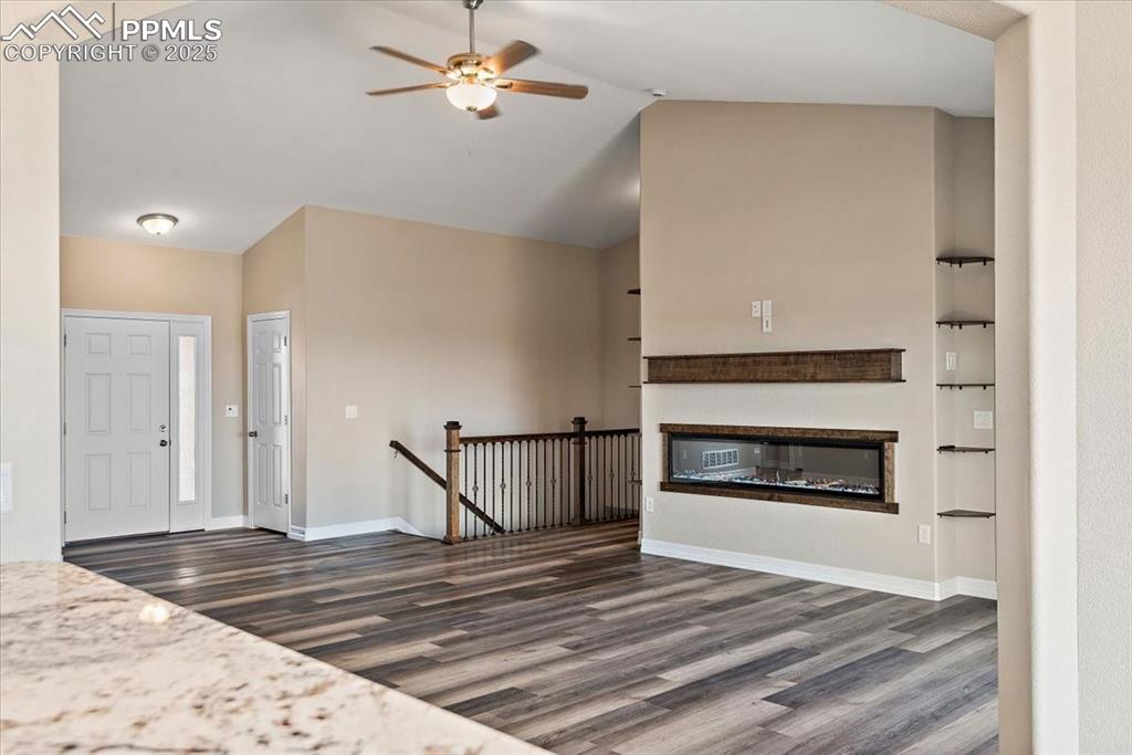 Image 6 of 45: Entrance foyer with baseboards, vaulted ceiling, and dark wood-style floori