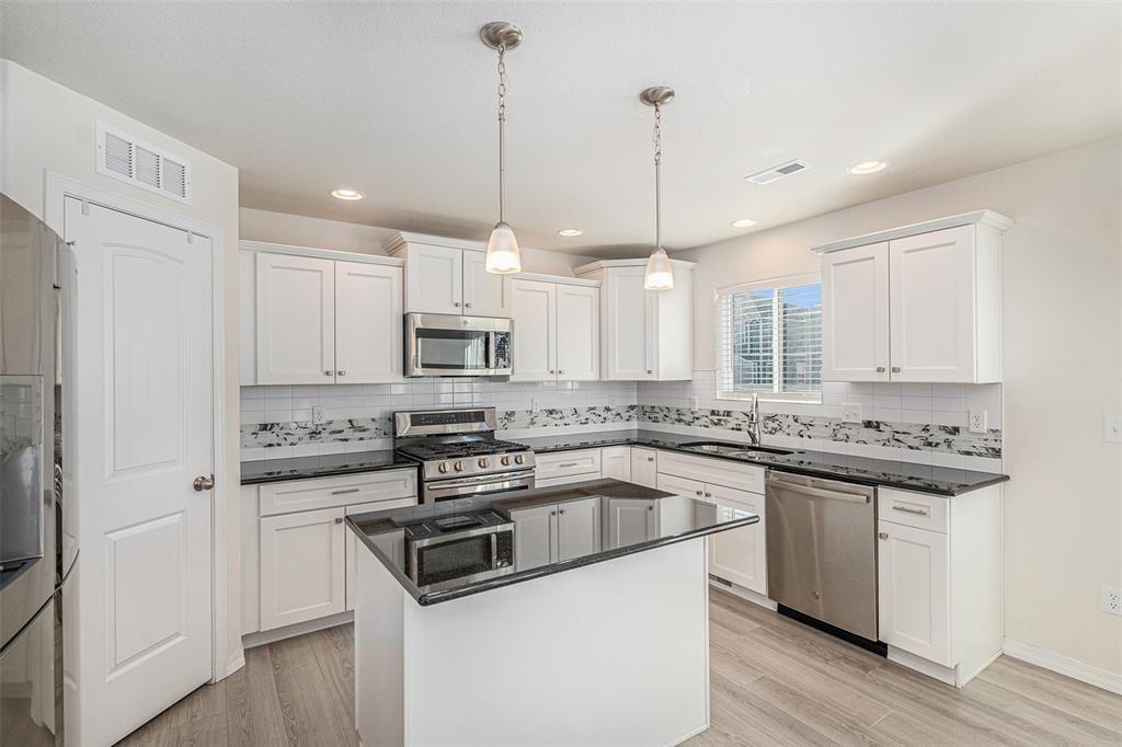 Image 12 of 33: Kitchen featuring pendant lighting, appliances with stainless steel finishe