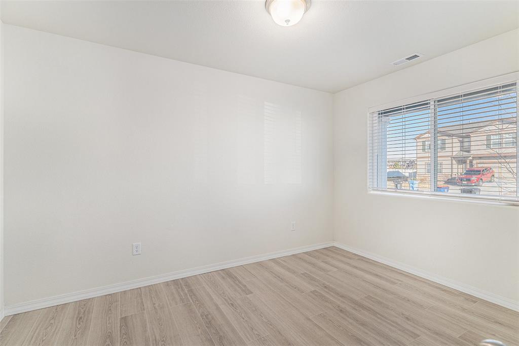 Image 14 of 33: Spare room with light wood-type flooring and baseboards