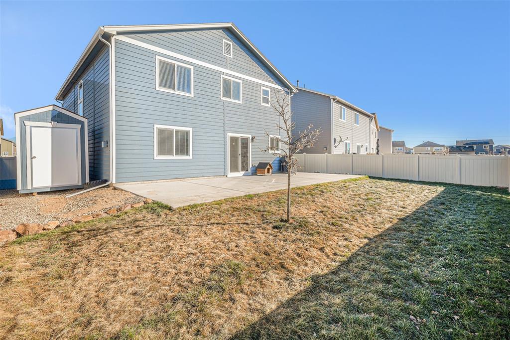 Image 31 of 33: Rear view of property with a storage unit, a patio, and a fenced backyard
