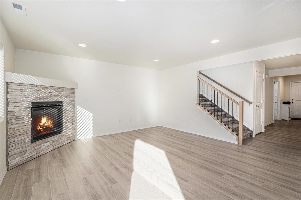 Image 7 of 33: Unfurnished living room featuring light wood-style flooring, stairway, a st
