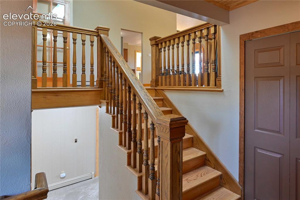 Image 10 of 40: Wood staircase with turned balusters and a paneled door
