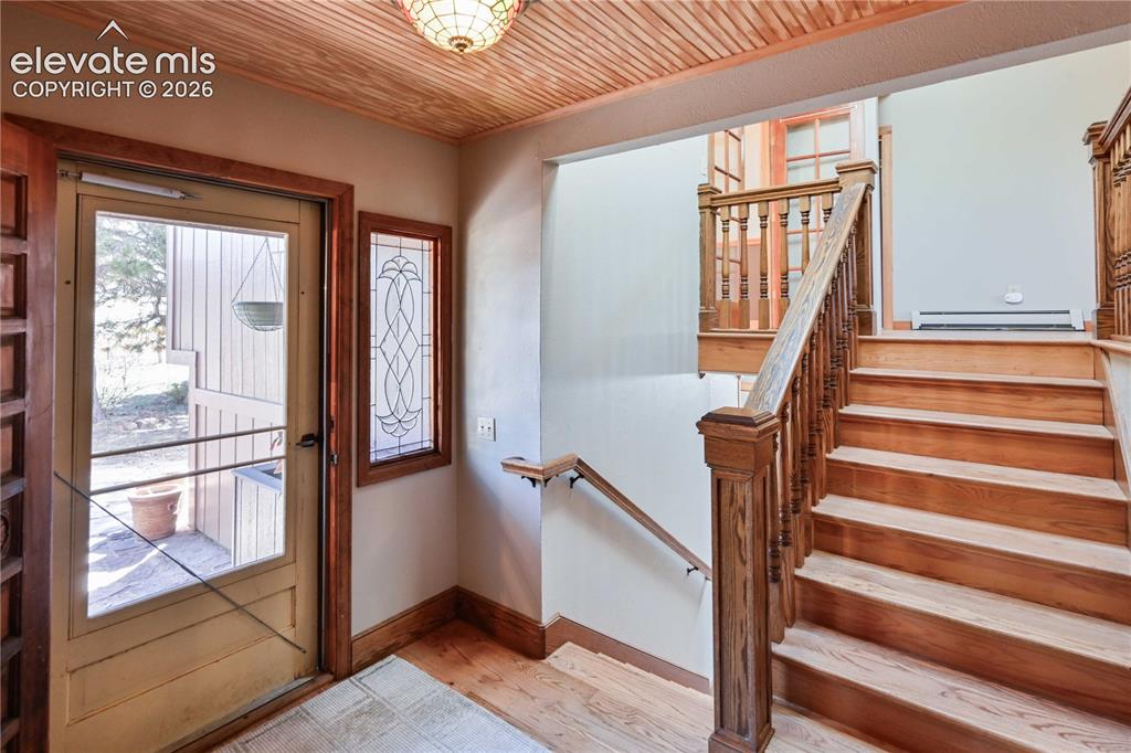 Image 11 of 40: Wood-finish ceiling, wood-finish flooring, stained wood staircase with balu