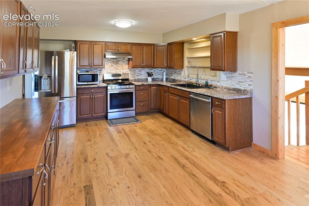 Image 14 of 40: Wood-finish flooring, full suite of stainless steel appliances, extensive c