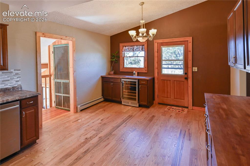 Image 16 of 40: Hardwood flooring throughout, built-in beverage refrigerator, wood-framed w