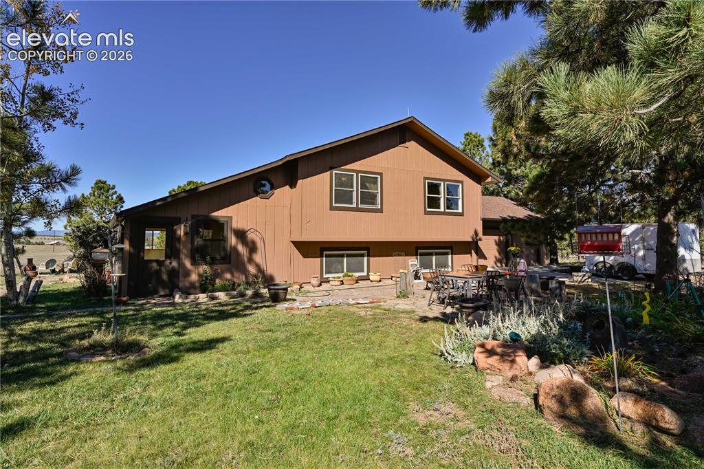 Image 2 of 40: Brown siding exterior with multiple windows, a round window accent, and a c