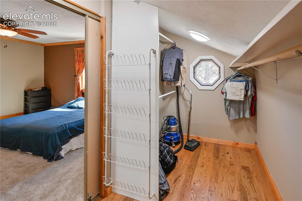 Image 20 of 40: Sliding mirrored closet door, wood-finish flooring, built-in shelving, octa