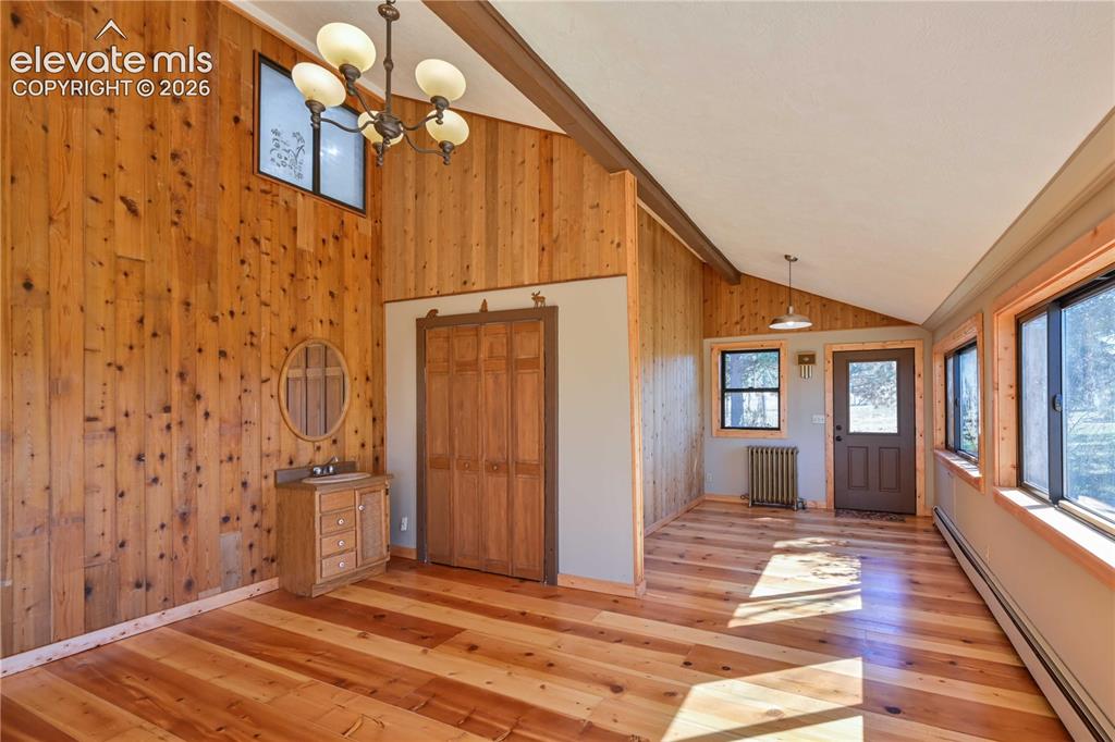 Image 24 of 40: Wood-paneled interior walls with a vaulted ceiling and exposed beam