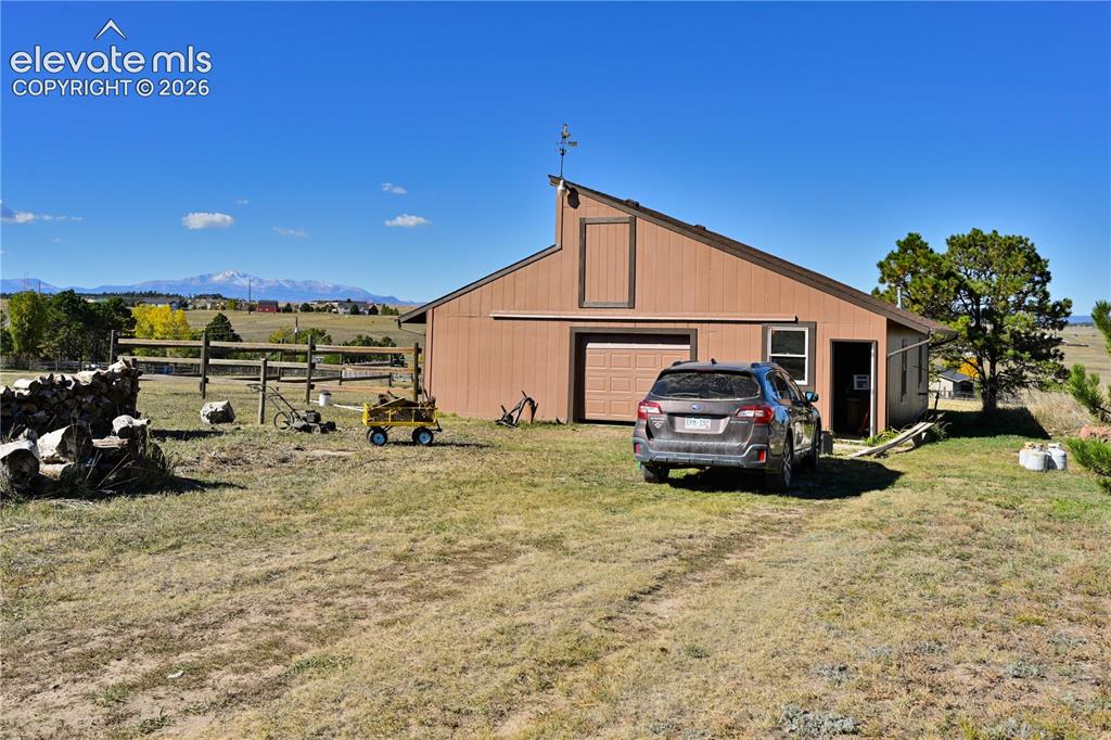 Image 35 of 40: Barn-style auxiliary building with a single garage door, a side entry door,
