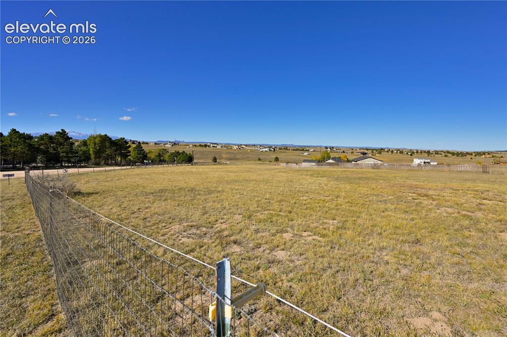 Image 39 of 40: Expansive open land with a wire fence, featuring distant residential struct