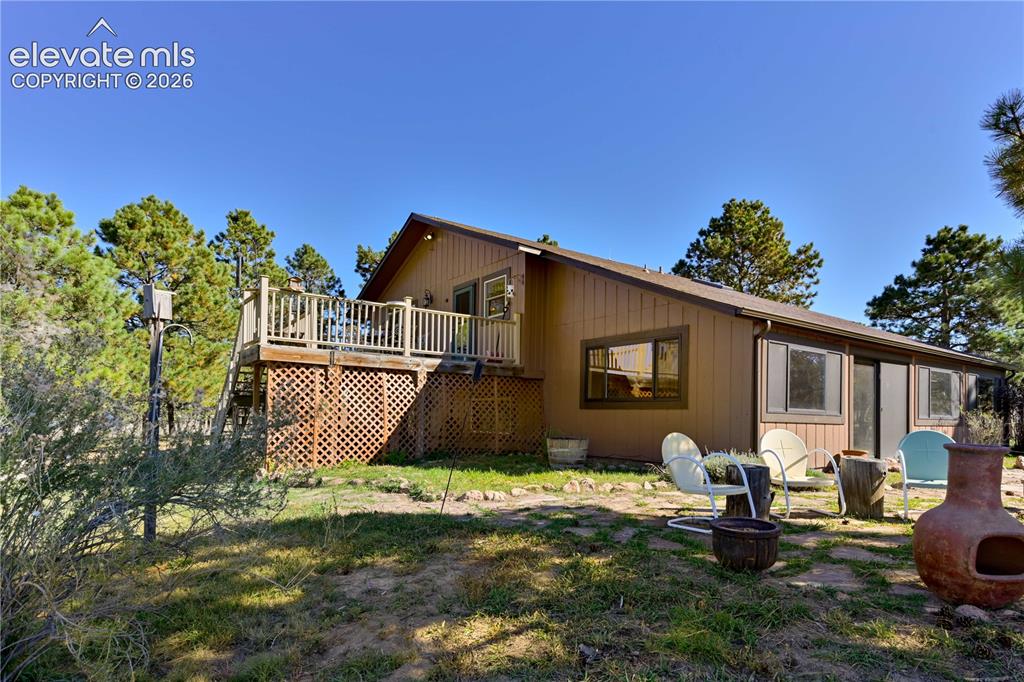 Image 6 of 40: Two-story wood deck with lattice skirting, featuring a sliding glass door e