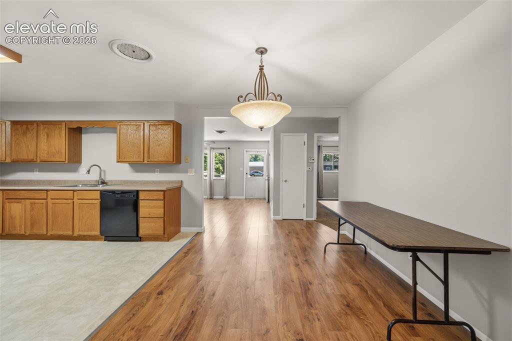 Image 10 of 36: Open-concept kitchen and dining area featuring wood-finish flooring, a cont