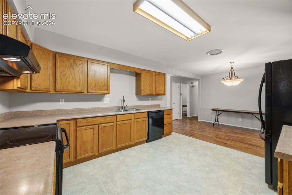 Image 12 of 36: Kitchen featuring wood cabinetry, laminate countertops, a stainless steel s