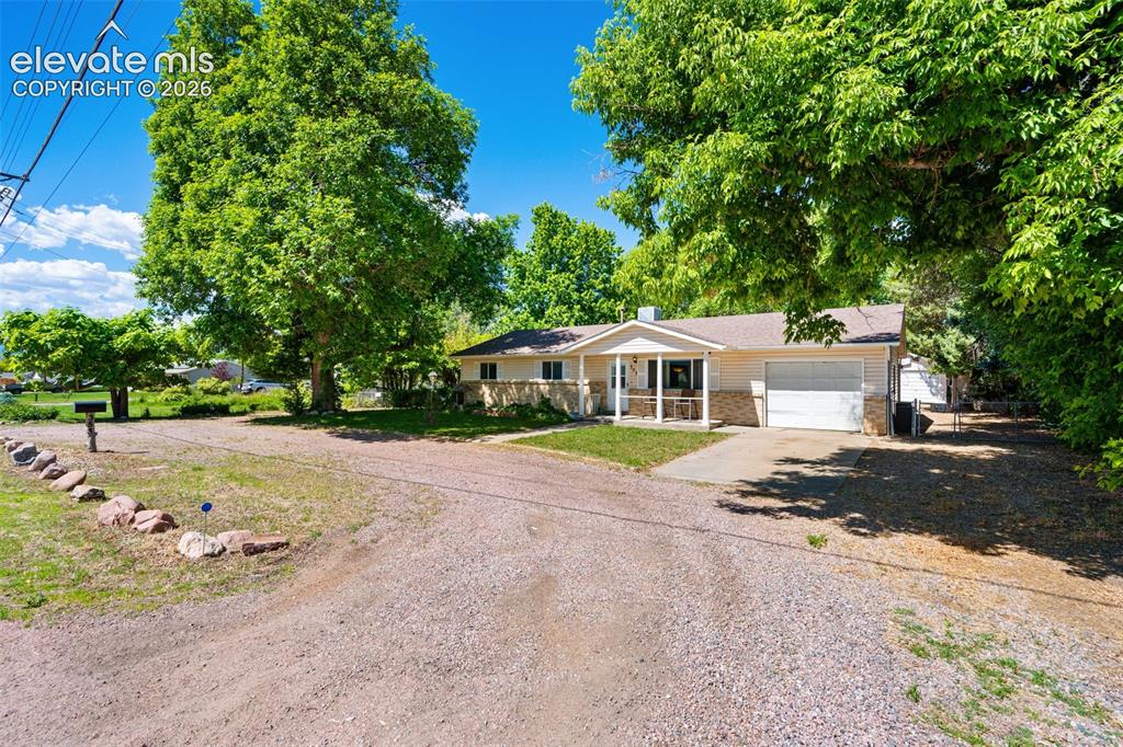 Image 3 of 36: Ranch-style residence featuring a covered front porch with white columns, a