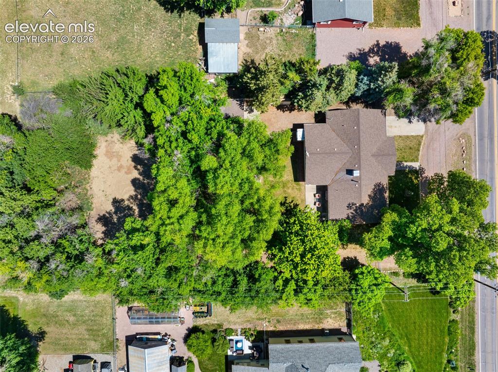 Image 36 of 36: Spacious lot featuring a residential structure with a shingled roof, extens