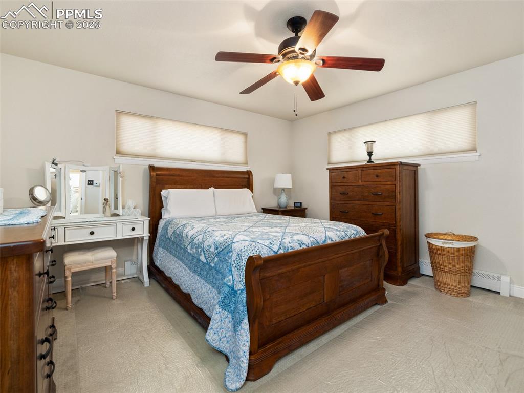 Image 13 of 39: Bedroom with light carpet, a ceiling fan