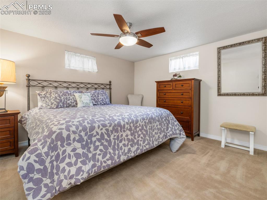Image 21 of 39: Bedroom with light carpet, a textured ceiling, and a ceiling fan