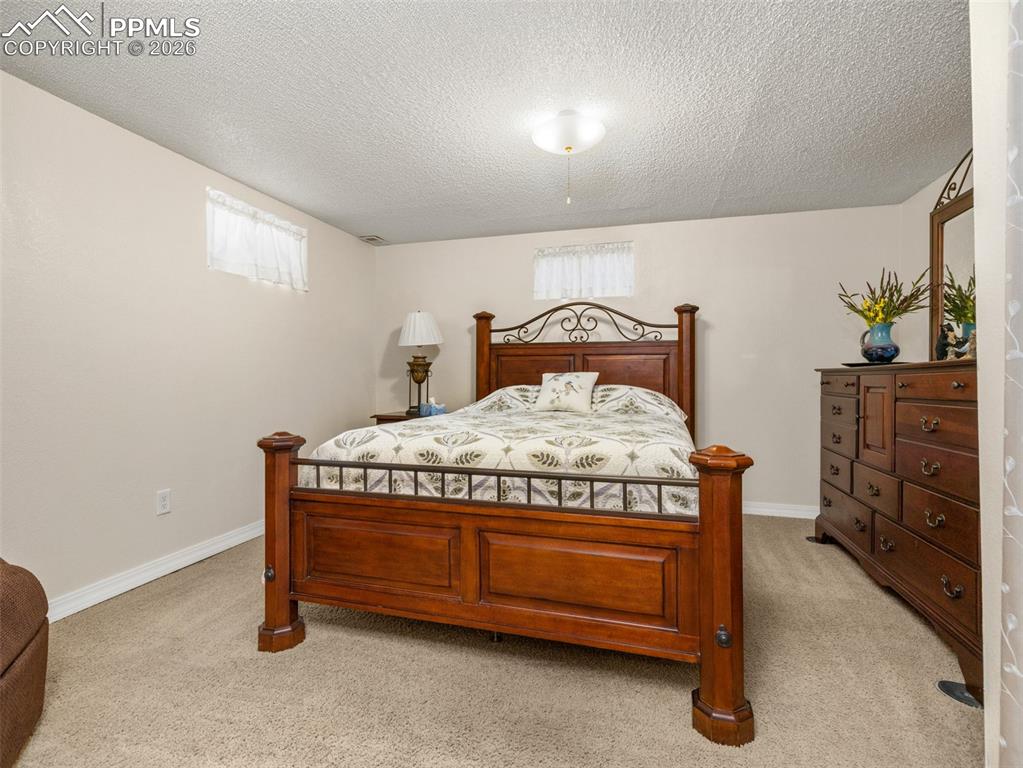 Image 22 of 39: Bedroom with a textured ceiling and light colored carpet