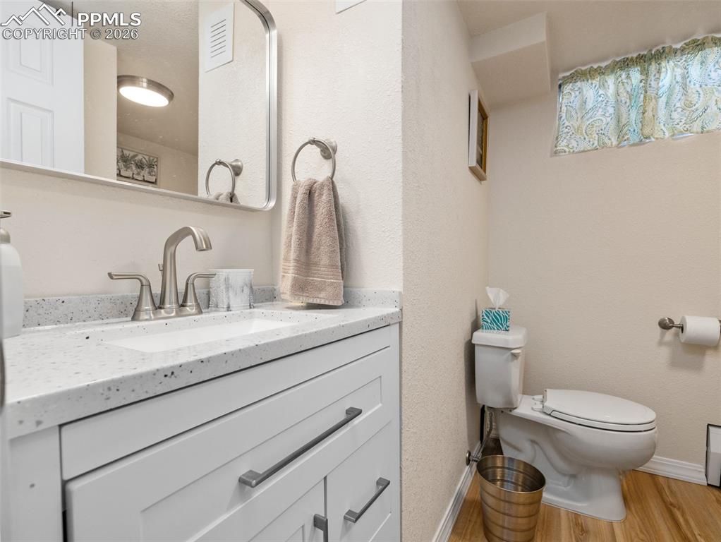 Image 23 of 39: Bathroom with light wood-type flooring, vanity, and a textured wall