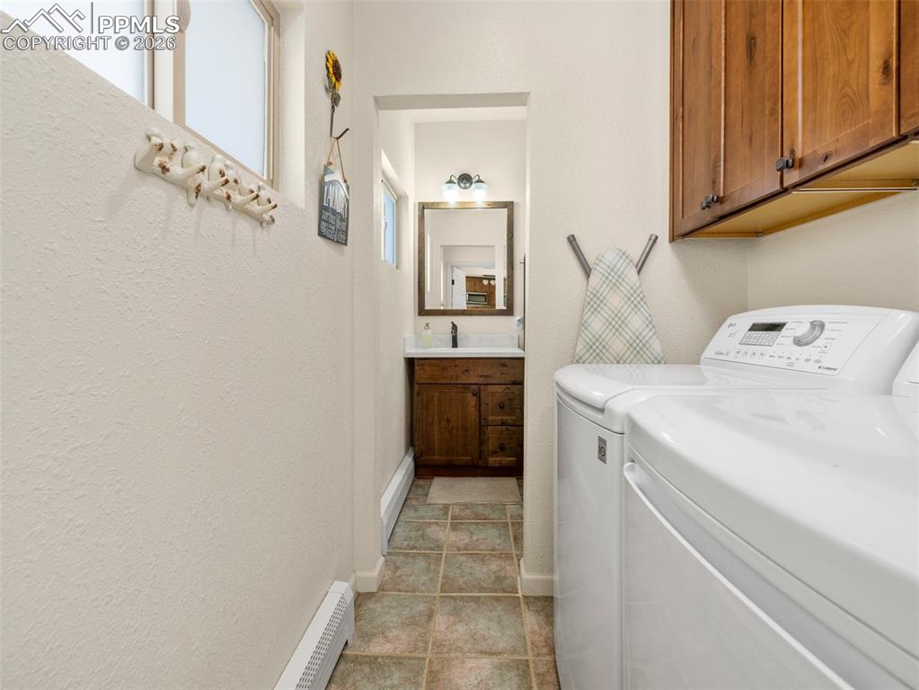 Image 8 of 39: Laundry room with view into 1/2 BA, independent washer and dryer, a baseboa