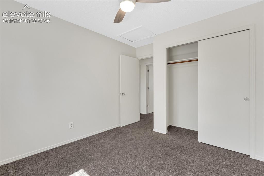 Image 18 of 33: Wall-to-wall carpeting, ceiling fan with light fixture, sliding closet door