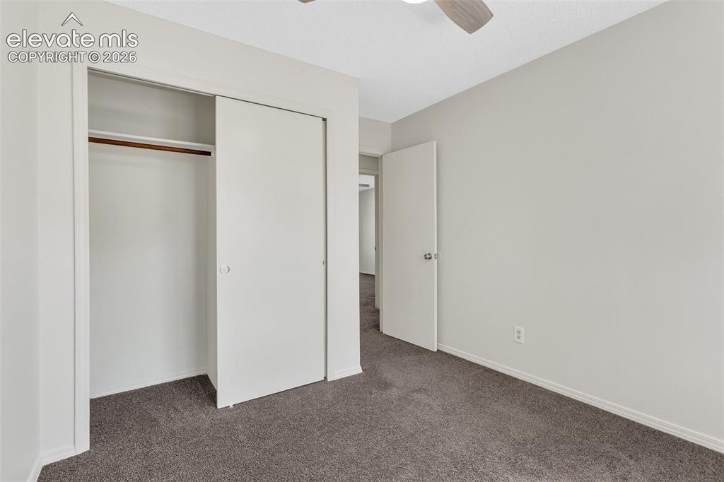 Image 21 of 33: Wall-to-wall carpeting and a ceiling fan with light fixture