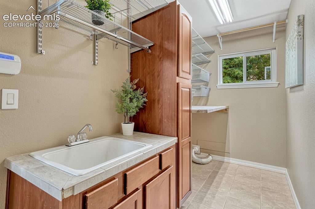 Image 30 of 50: main level laundry with utility sink.