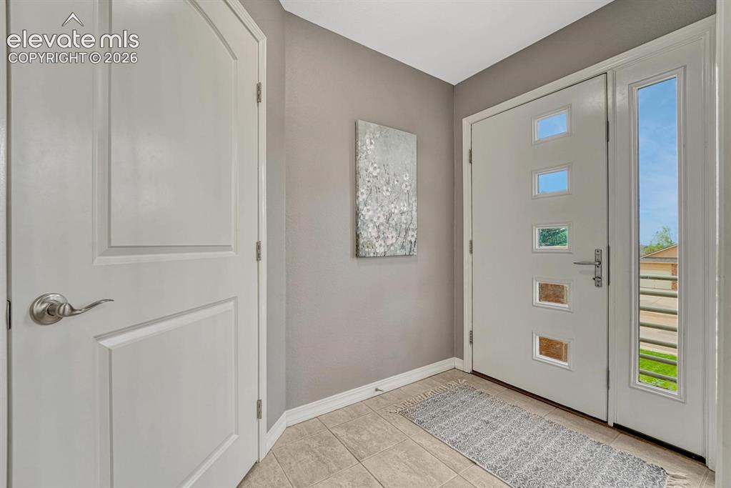 Image 7 of 50: Welcoming foyer with French doors for energy efficiency