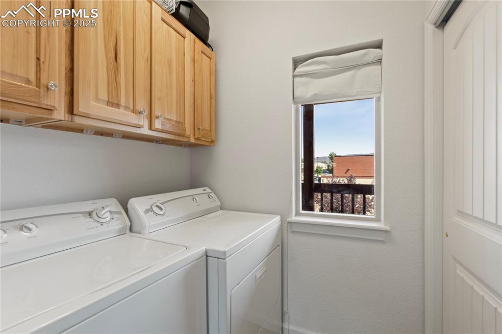 Image 9 of 27: The laundry space is bright and open with plenty of storage cabinets.