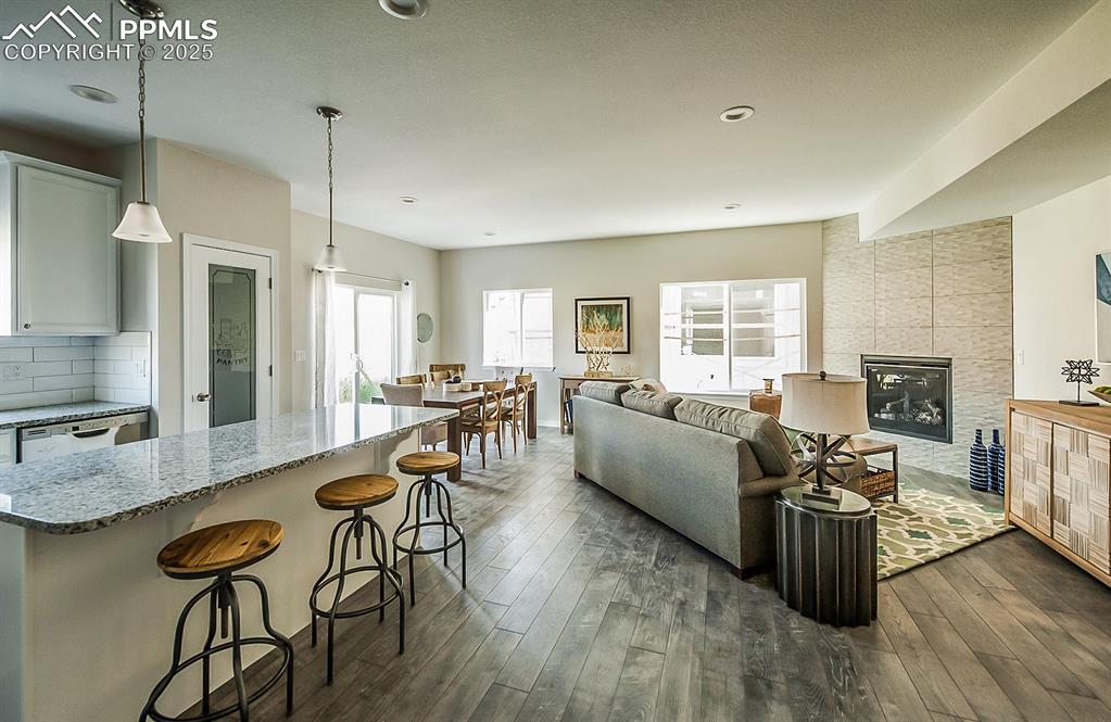 Image 10 of 48: Open concept main level with luxury vinyl floors and fireplace