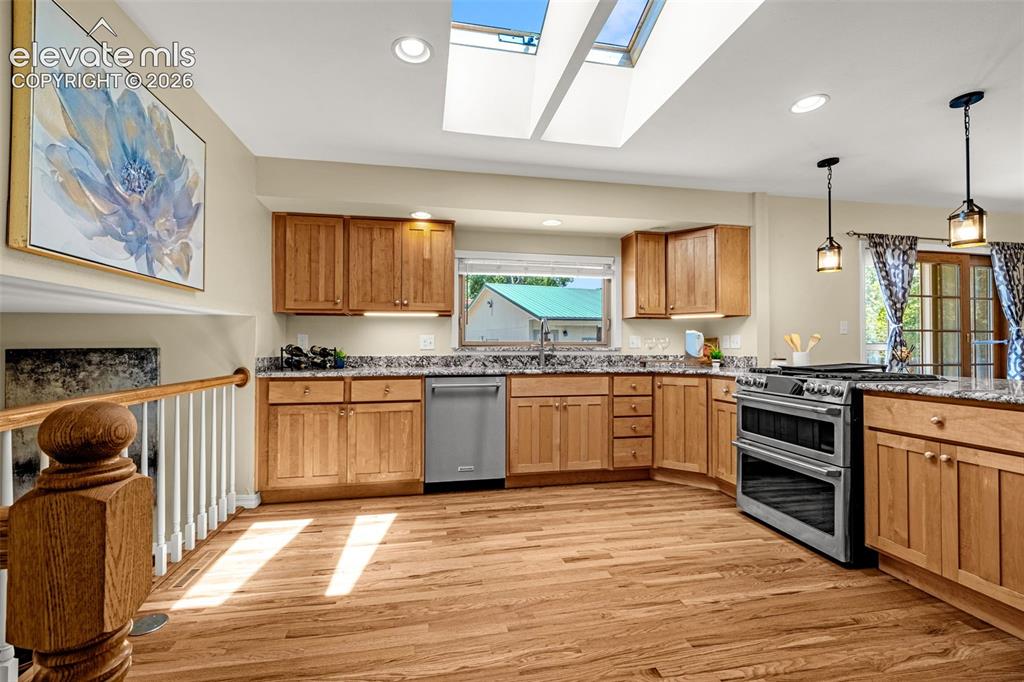 Image 10 of 38: Kitchen featuring skylights, wood-finish flooring, light wood cabinetry, st