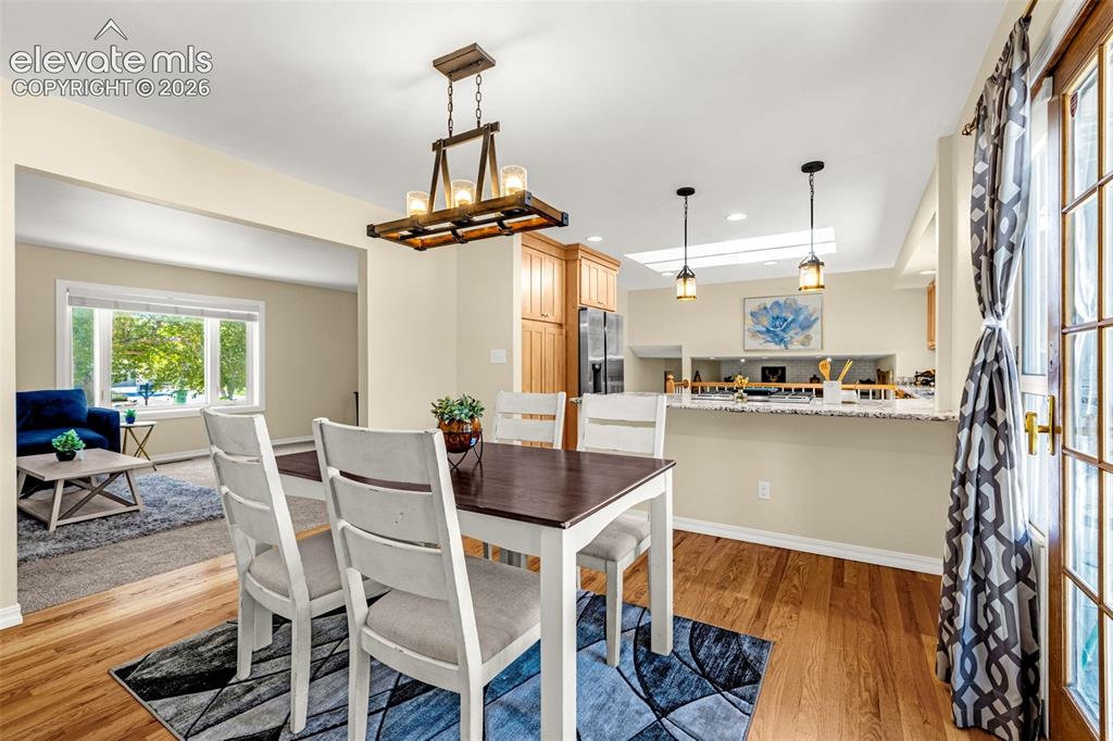 Image 16 of 38: Dining area featuring wood-finish flooring, a contemporary chandelier, and