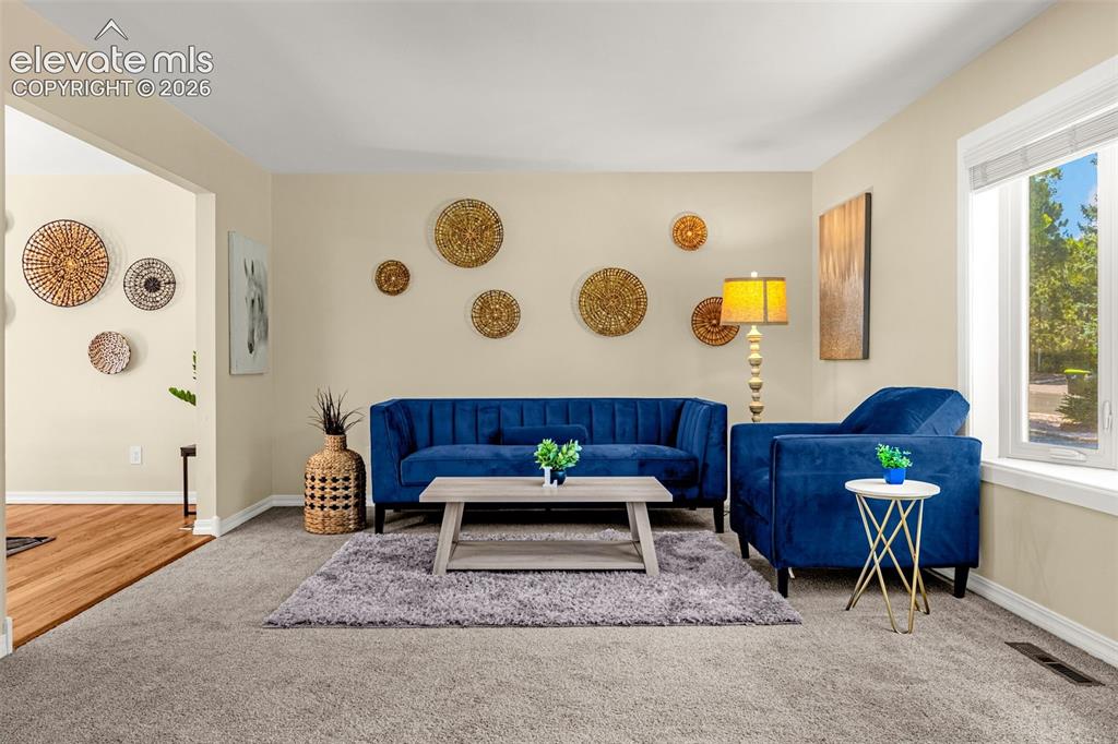 Image 17 of 38: Living area featuring neutral wall tones, plush gray carpeting, white trim,