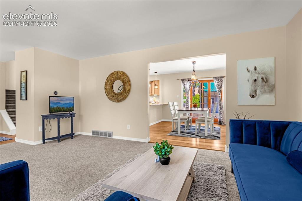 Image 18 of 38: Carpeted living area featuring light-toned walls and white trim