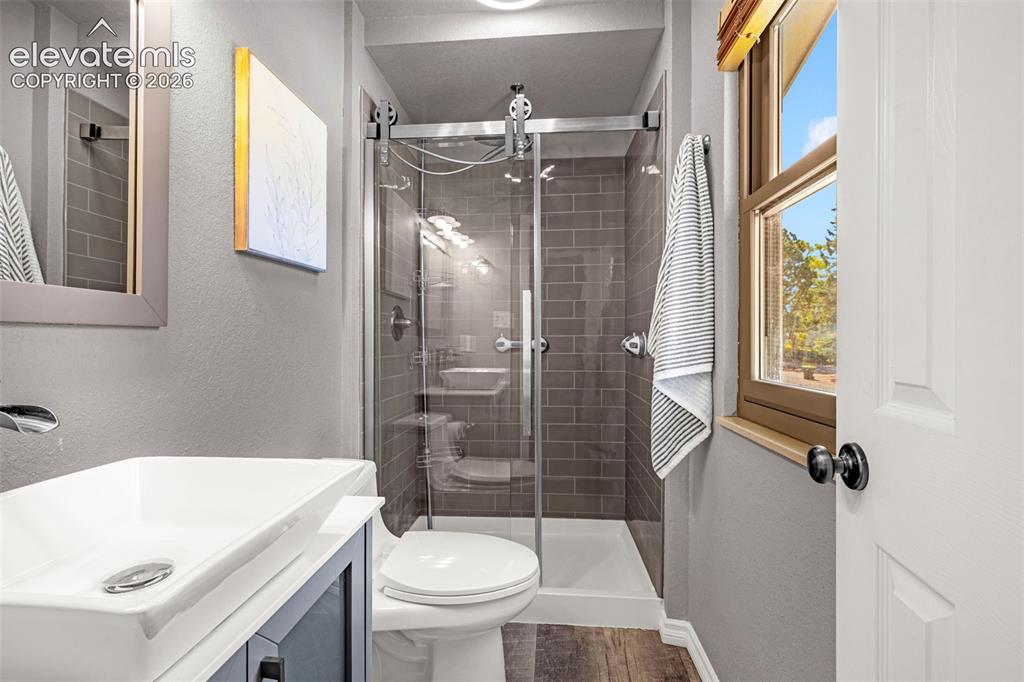 Image 25 of 38: Modern bathroom featuring a glass-enclosed shower with subway tile surround